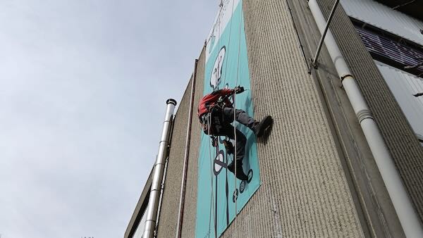 Trabajo vertical de colocación de una pancarta en Barberá